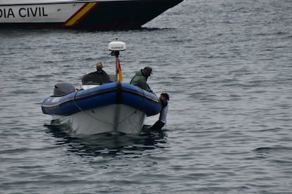 La Guardia Civil ayuda a un inmigrante a acercarse a la playa del Tarajal, este martes.