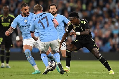 Vinícius Júnior intenta abrirse paso entre los jugadores del Manchester City, Kyle Walker y Kevin De Bruyne. 