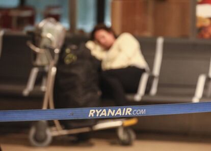 Una pasajera duerme junto a su equipaje en el aeropuerto de Madrid durante la huelga de Ryanair.