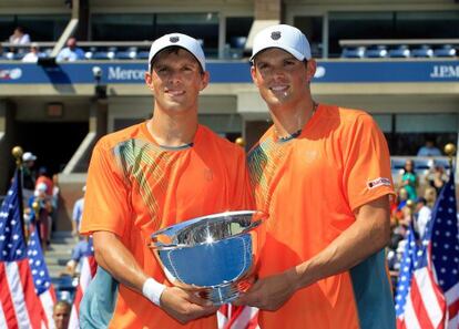 Mike Bryan y Bob Bryan posan con el trofeo de campeones del US Open.