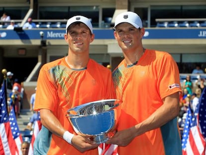 Mike Bryan y Bob Bryan posan con el trofeo de campeones del US Open.