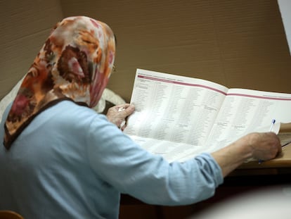 Una mujer lee la papeleta electoral antes de votar en un colegio de Sarajevo, este domingo.