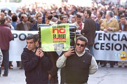 Unos agricultores del sector del tomate llevan a hombros un féretro en un gesto simbólico, durante la protesta.