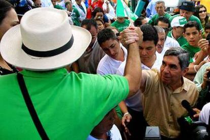 El ex presidente de Costa Rica Óscar Arias saluda a un seguidor antes de depositar su voto.