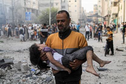 Un palestino cargaba a una niña herida durante un ataque israelí en Jan Yunis, al sur de Gaza, el sábado.