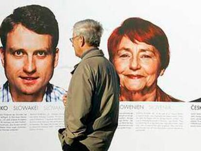 Dos hombres observan los retratos de ciudadanos de cada uno de los 27 Estados miembros expuestos en Berlín con motivo del 50º aniversario de la UE.