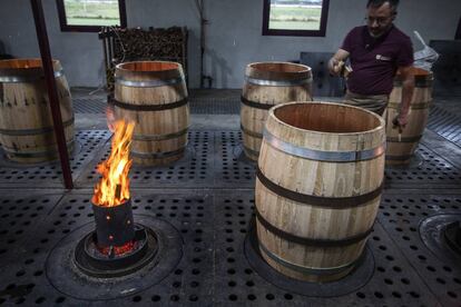 Éric Nicolas introduce astillas de roble para ahumar una barrica.