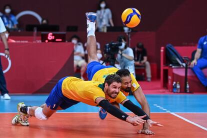 Los brasileños Bruno Rezende y Mauricio de Souza se lanzan a por el balón en el partido de voleibol masculino de la ronda preliminar del grupo B entre Brasil y Argentina durante los Juegos Olímpicos de Tokio 2020.