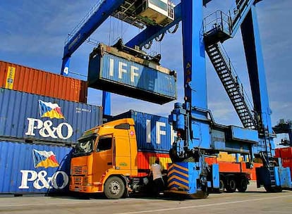 Una grúa carga contenedores en un camión, en la terminal de contenedores del Puerto de Bilbao.