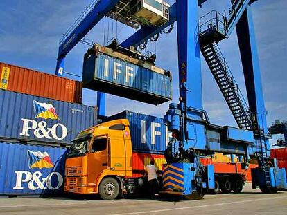 Una grúa carga contenedores en un camión, en la terminal de contenedores del Puerto de Bilbao.