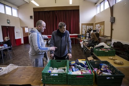 Chris ayuda a dar comida a un hombre necesitado en el banco de alimentos de Newcastle, el 23 de enero.