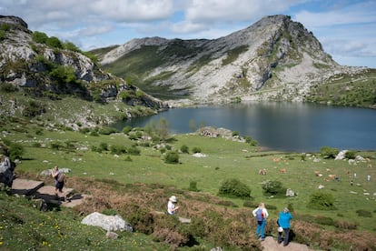 Varios excursionistas junto al lago Enol, uno de los Lagos de Covadonga.