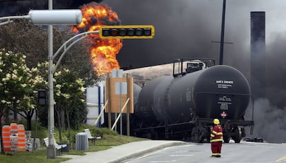 Un bombero camina cerca de uno de los vagones del tren siniestrado en la ciudad de Lac Megantic, Quebec,