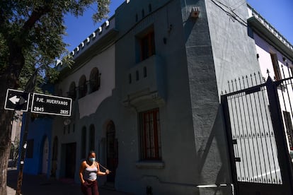 Una mujer camina afuera de la casa donde vive el presidente Gabriel Boric.