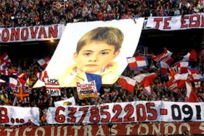 Aficionados del Atlético de Madrid despliegan un enorme cartel con la imagen de Dónovan y el número de teléfono de su familia.