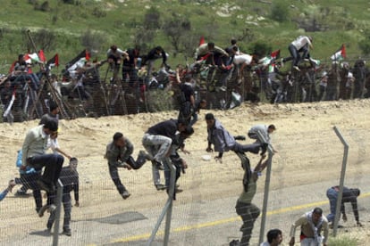 Varios manifestantes palestinos trepan la valla fronteriza entre Siria e Israel, en la localidad de Majdal Shams, duranta las protestas de la conmemoración del Día de la Catástrofe, que recuerda el exilio palestino tras la creación del Estado de Israel en 1948.