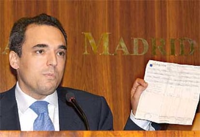 Rafael Simancas muestra un documento sobre sus propiedades durante una rueda de prensa.