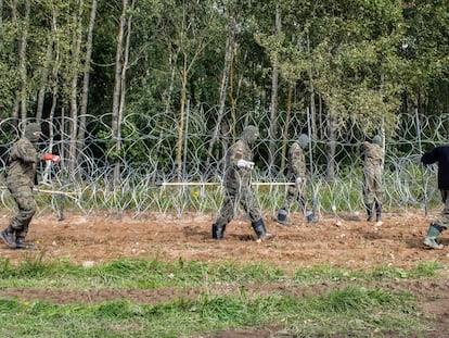 Soldados polacos construyen una valla de alambre de púas a lo largo de la frontera con Bielorrusia, cerca de la aldea de Minkowce, el pasado mes de septiembre.