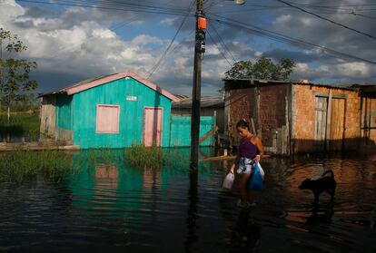 Una mujer cruza la calle inundada. 35 municipios de la región del Amazonas se enfrentan a las peores inundaciones de años recientes y aún se espera que la situación empeore.