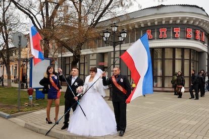 Casal recém-casado é fotografado segurando bandeiras russas em Simferopol, capital da República Autônoma da Crimeia na Ucrânia.