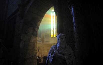 Un cofrade encapuchado de la hermandad La Borriquita participa en una procesión de Semana Santa en Córdoba.