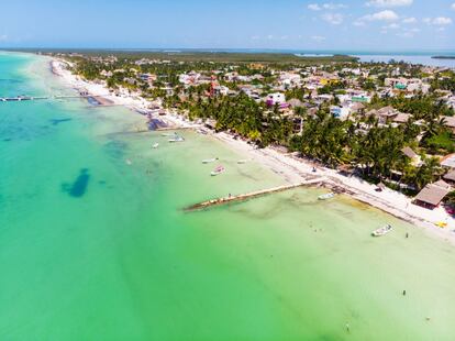 De mediados de mayo a finales de agosto, enormes tiburones ballena de hasta 15 toneladas y 15 metros de largo se concentran en los alrededores de Holbox, en Yucatán, para alimentarse del plancton. La mejor época para ver a “los dominós” (así les llaman los lugareños, por las manchas de su piel) es en julio y agosto, que coincide con la temporada media turística, cuando puede haber una veintena de barcos alrededor de un solo animal. El Fondo Mundial para la Naturaleza trabaja desde 2003 con la comunidad local para desarrollar prácticas responsables en estos encuentros y conseguir un equilibrio entre la explotación económica y la protección de las especies amenazadas. La isla Holbox tiene calles de arena, coloridos edificios caribeños y unas playas de arena tan fina que parece arcilla. El característico color verdoso de sus aguas se debe a la mezcla de las corrientes oceánicas, pero en tierra también se produce otra combinación: la de isleños y turistas deseosos de escapar del alboroto de la más abarrotada Cancún.