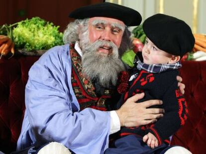 Olentzero escucha a un niño en el Teatro Arriaga de Bilbao.