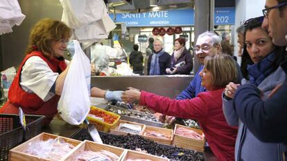 Unos compradores realizan sus compras en un mercado de Bilbao.
