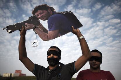 Un manifestante sostiene el retrato del fotógrafo y activista Ahmed Humaidan, condenado a diez años de cárcel acusado de atacar una comisaría en 2012, durante una protesta en Jannusan (Baréin).