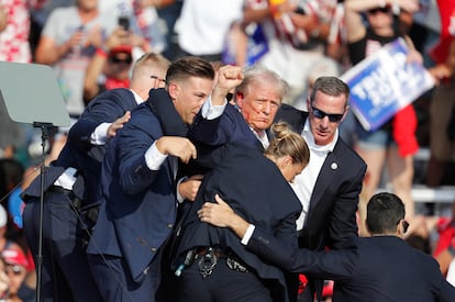 El expresidente estadounidense Donald Trump es sacado del escenario por el Servicio Secreto.