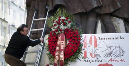 Un hombre coloca una corona de flores en el homenaje a las v&iacute;ctimas de Atocha.