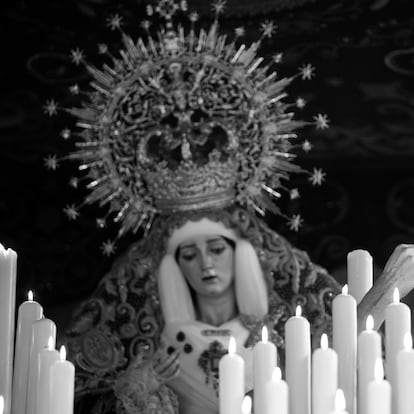 MÁLAGA, 05/04/2023.- Un hermano de la Cofradía de Jesús El Rico y María Santísima del Amor, enciende la candelería del trono de la Virgen momentos antes de iniciarse el desfile procesional en este miércoles de la Semana Santa malagueña. EFE/ Daniel Pérez