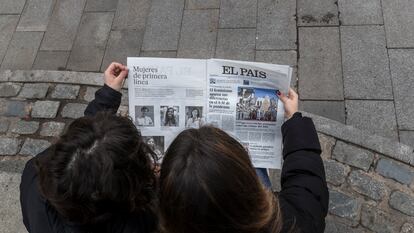 Dos jóvenes leen el diario EL PAÍS.