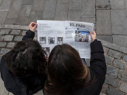 Dos jóvenes leen el diario EL PAÍS.