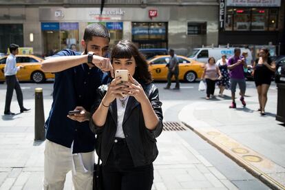 Sameer Uddin y Michelle Macias juegan a 'Pokemon Go' frente a la tienda Nintendo en Nueva York, EEUU.