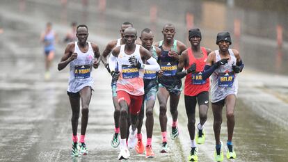 Kipchoge tira del grupo de los favoritos en el maratón de Boston.  Tras su codo izquierdo, el ganador, Chebet.