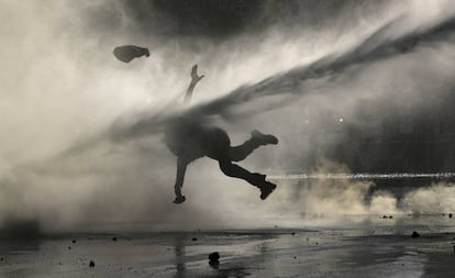 Una manifestante recibe el golpe de un chorro de agua durante una manifestación de protesta realizada en Santiago el 9 de diciembre.