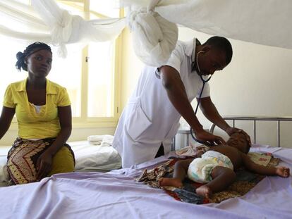 Um médico atende um bebê internado por malária em um hospital de Moçambique.