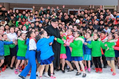 El líder norcoreano Kim Jong Un es abrazado por niños durante su visita al condado de Samjiyon (Corea del Norte).