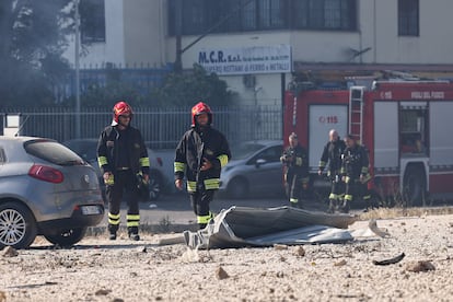 Bomberos y personal de emergencias junto a los restos del deposito de gas licuado de petróleo (GLP) que ha explotado a primera hora de la mañana de este viernes al sureste de Roma.