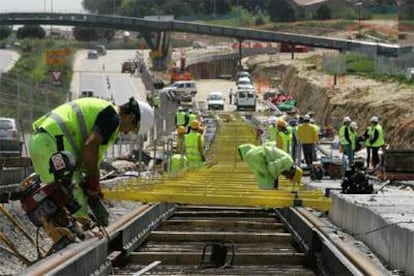 Varios obreros miden tramo a tramo la inclinación de los raíles del metro ligero el pasado lunes en Pozuelo.