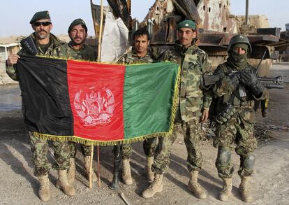 Los soldados afganos llegan al centro de Showal, en Helmand, y muestran con orgullo la bandera de Afganistán