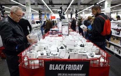 Varios compradores observan los productos en promoci&oacute;n de la tienda Media Markt, en la calle Alcal&aacute; de Madrid.