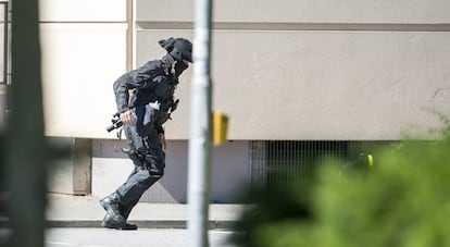 Un polic&iacute;a junto al cine en el que se ha producido el tiroteo.