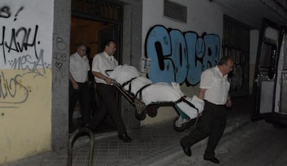 Empleados de una funeraria retiran el cadáver de la mujer.