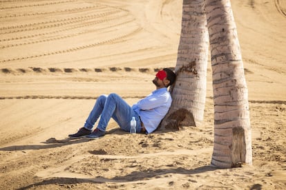 Un hombre duerme la siesta en la playa.