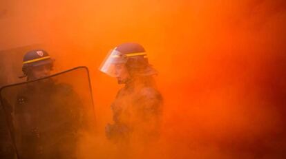 Una policía rodeada de humo durante una manifestación de trabajadores en las calles de París.