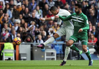 Cristiano Ronaldo (izquierda) del Real Madrid lanaza el balón ante Pablo Insua del Leganes.