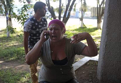 Una migrante cubana habla por teléfono móvil después de que la policía antidisturbios disparara gases lacrimógenos en la frontera entre Nicaragua y Costa Rica.