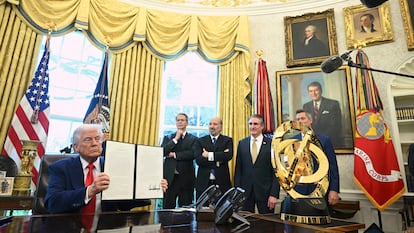 El presidente de EE UU, Donald Trump, muestra un decreto presidencial con su firma junto a algunos de sus colaboradores, el 9 de abril en la Casa Blanca.